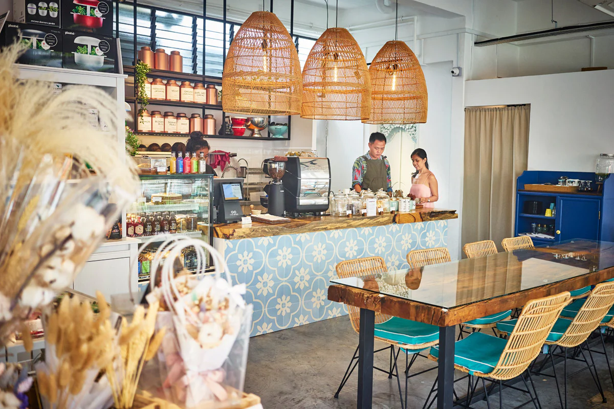 Interior of The Social Space cafe in Tanjong Pagar, Singapore, with baristas at the counter, rattan pendant lights and dried-flower decor