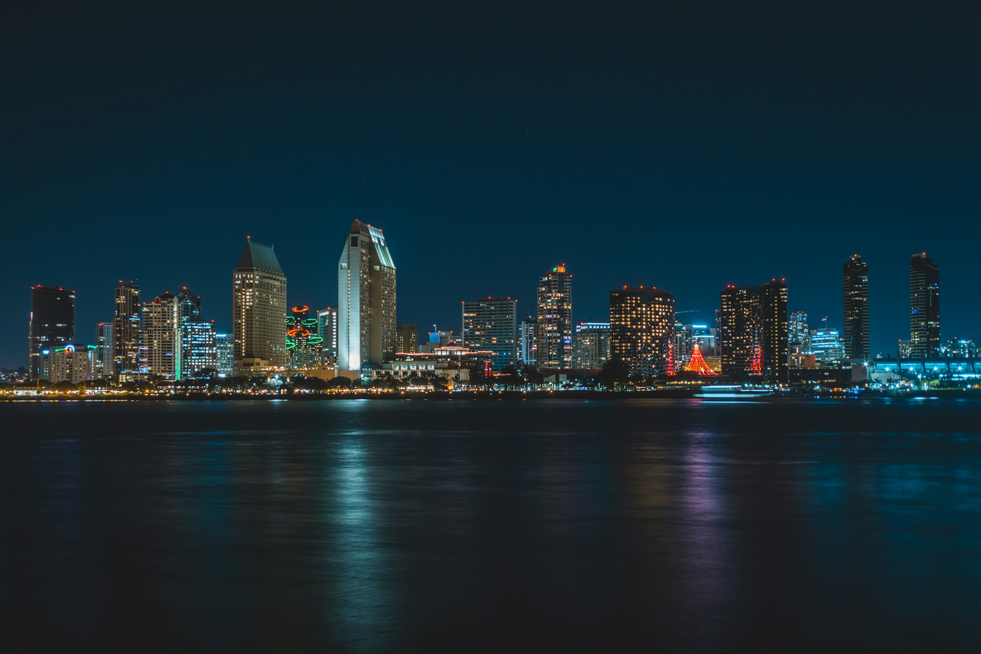 San Diego downtown skyline lit up at night reflected in the bay water