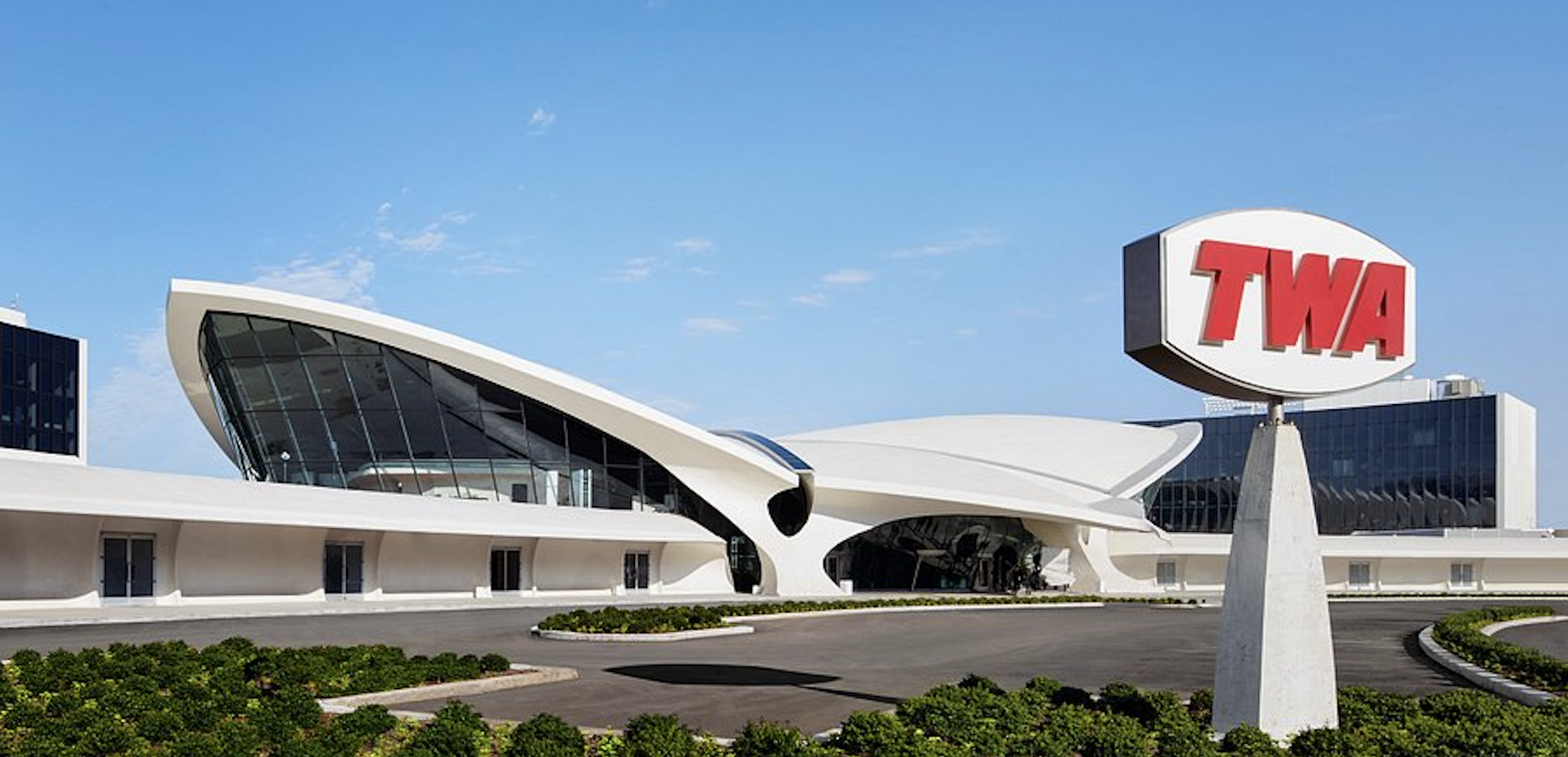 The landmark TWA Hotel at JFK Airport, with its sweeping white mid-century terminal and red TWA sign