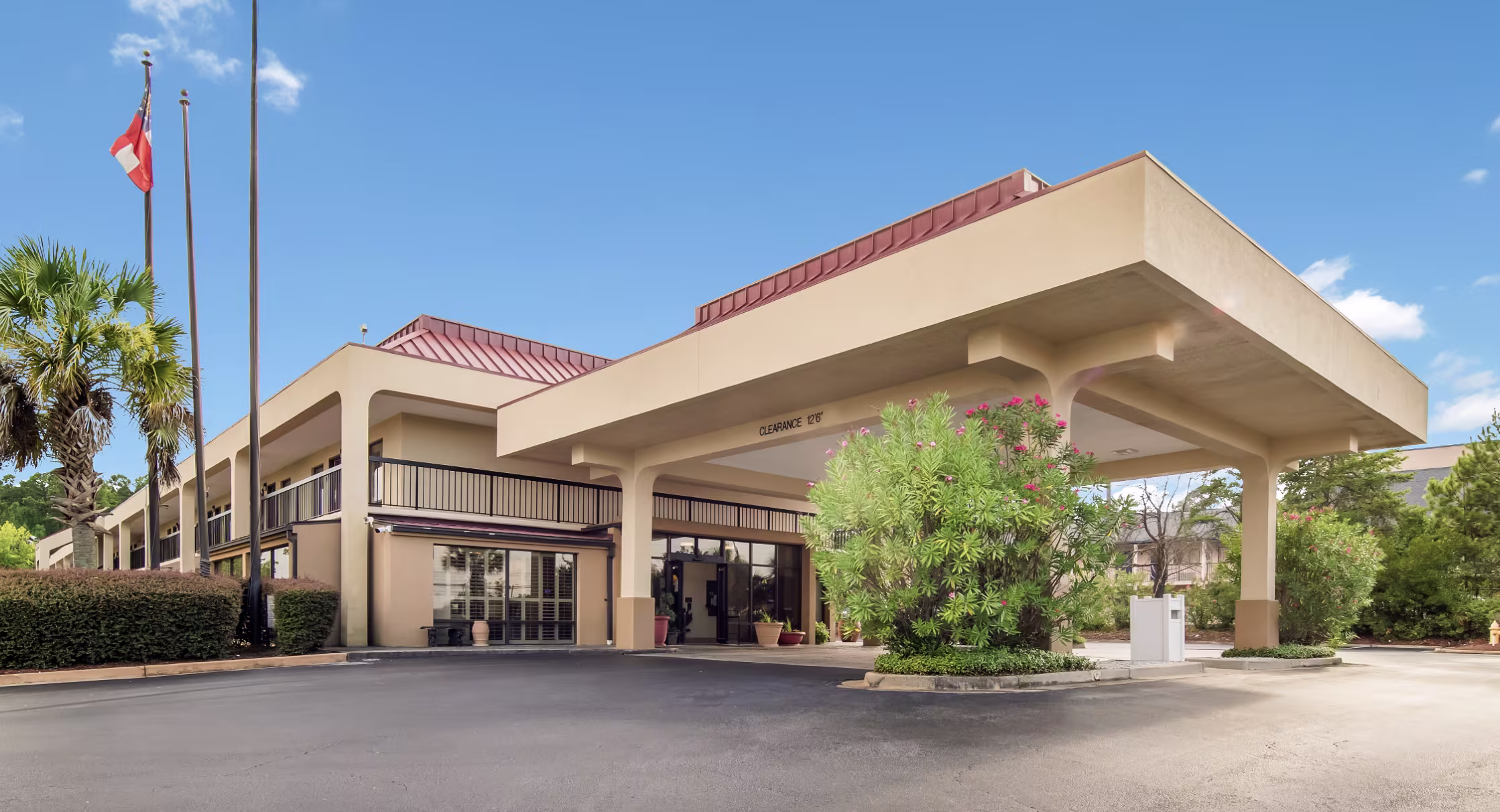 Covered hotel entrance and portico of an Augusta property under a clear blue sky