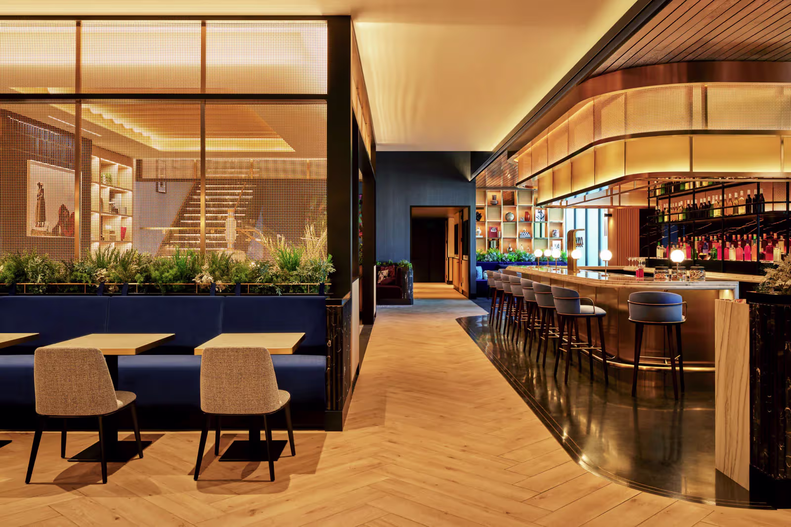 Modern airport lounge with a wood-paneled bar, seating and herringbone floors at Las Vegas airport