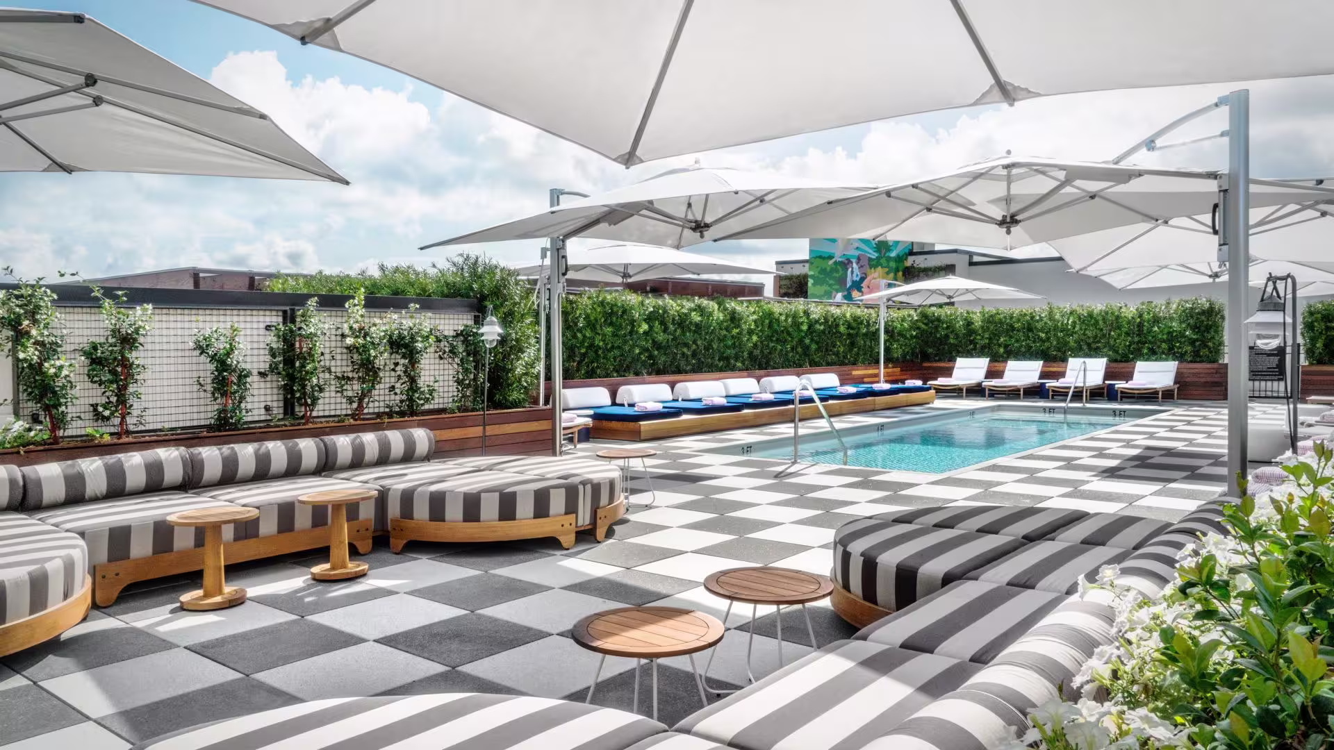 The DeSoto Savannah rooftop deck with striped lounge seating around a pool under white umbrellas