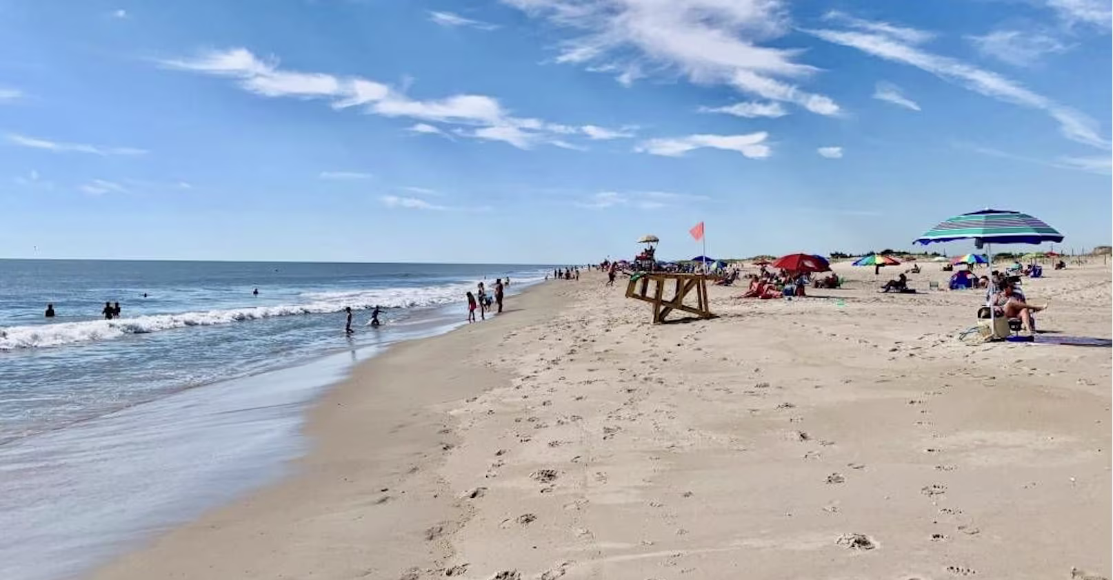 Aerial view of the Outer Banks, North Carolina shoreline with beachgoers and umbrellas