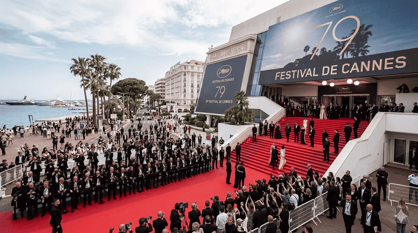 Crowd on the red-carpet steps of the Palais des Festivals at the Cannes Film Festival, with photographers lining the entrance