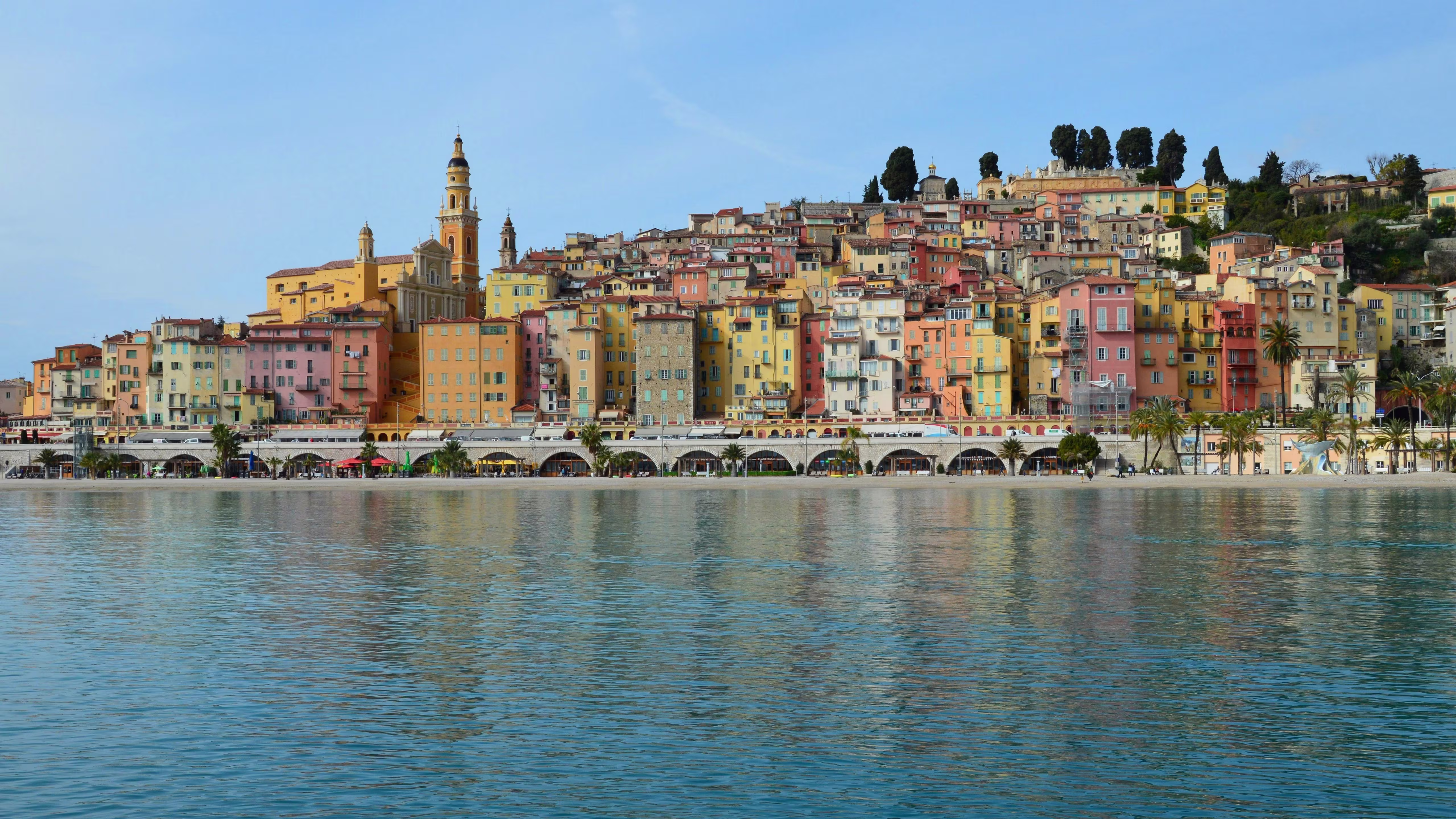 Pastel-colored hilltop old town of a French Riviera coastal town rising above the sea near Monaco